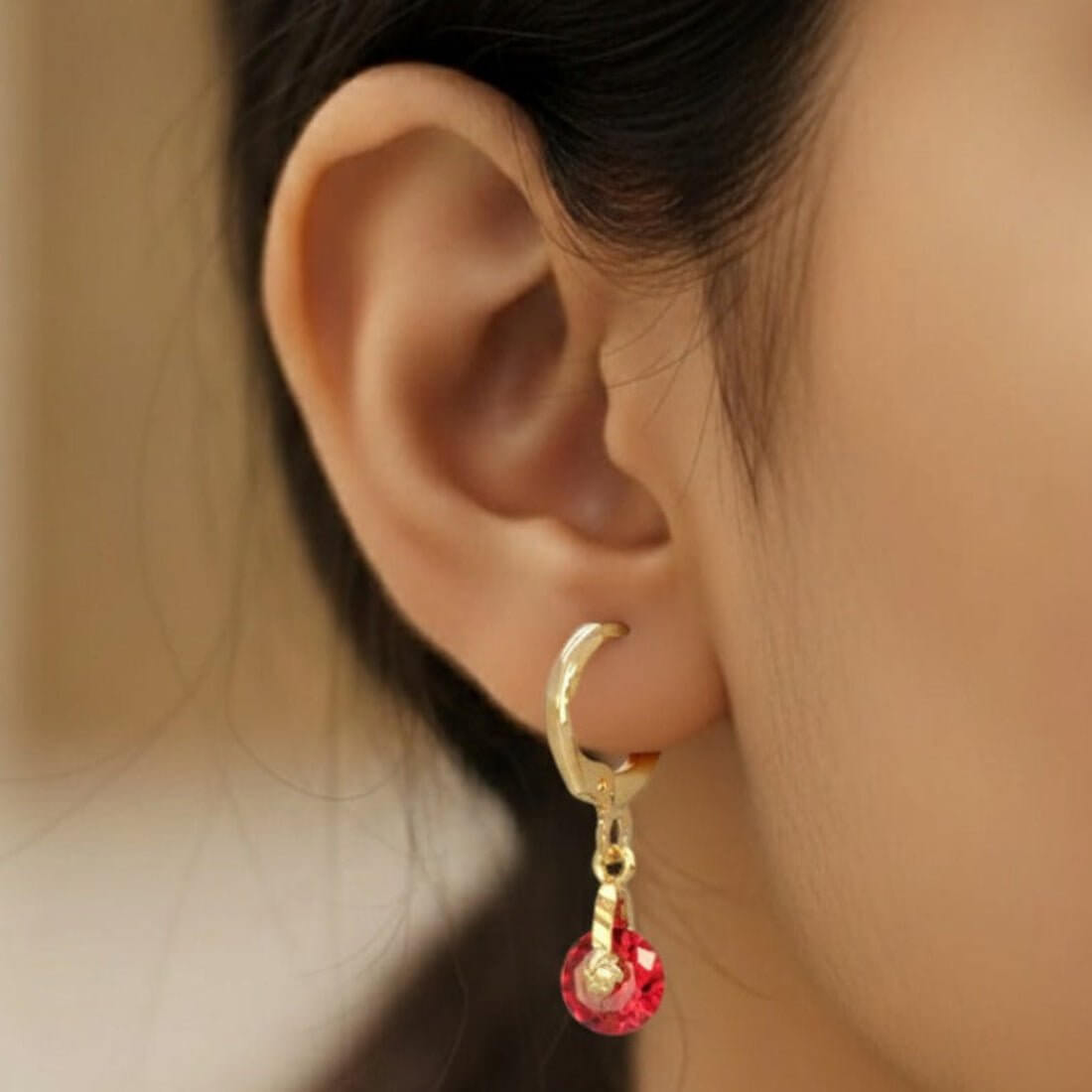 Gold hoop earring with a red gemstone, part of the Hoops & Bali collection.