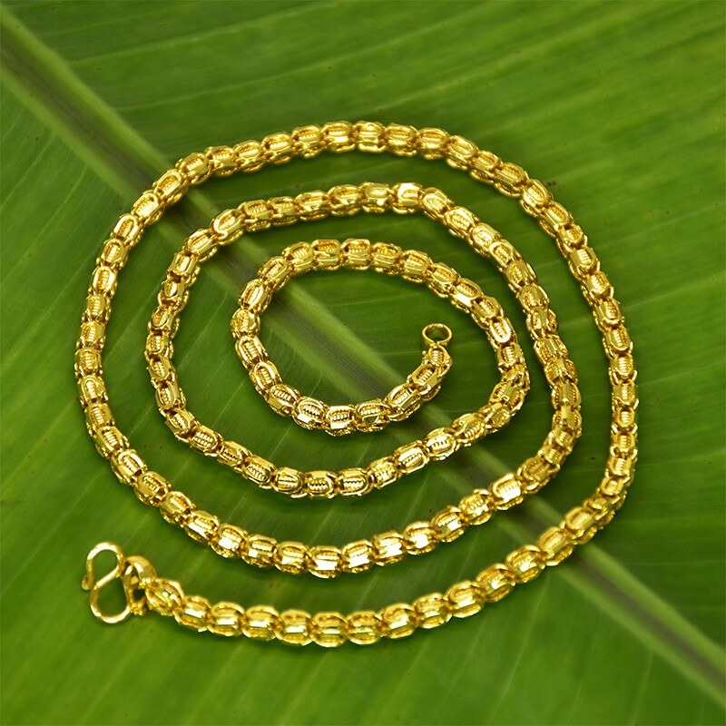Premium Gold Plated Designer Thennampoo Chain elegantly displayed on a green leaf background.