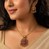 Pink Stone Antique Lakshmi Pendant Necklace Set worn by a woman, showcasing intricate design and vibrant pink stone.