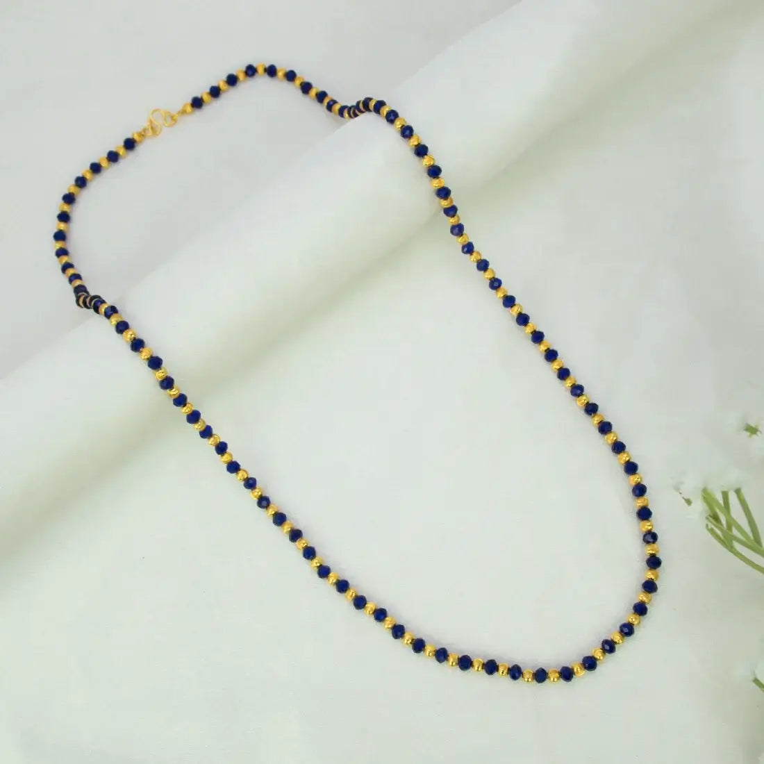 Alternating blue crystal and golden bead chain for women with faceted blue and gold round beads in a precise striped pattern