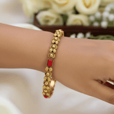 Antique Gold-Plated Coral Red Stone Bangle worn on wrist, showcasing intricate beadwork and coral red stones.