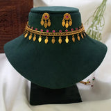 Antique Gold Plated Curb Link Elakkathali Choker Set displayed on a green velvet stand, featuring ruby-toned kemp stones and gold leaf-shaped danglers.