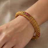 Antique Gold Plated Kemp Stone Kada Bangle worn on wrist showcasing intricate design and ruby red stones.
