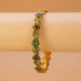 Antique Heart Floral Kemp Stone Victorian Bangle displayed on a wrist, featuring intricate gold design with colorful stones.