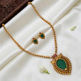 Antique Kerala Traditional Teardrop Pendant Necklace Set arranged on white satin fabric with a dark carved wooden block.