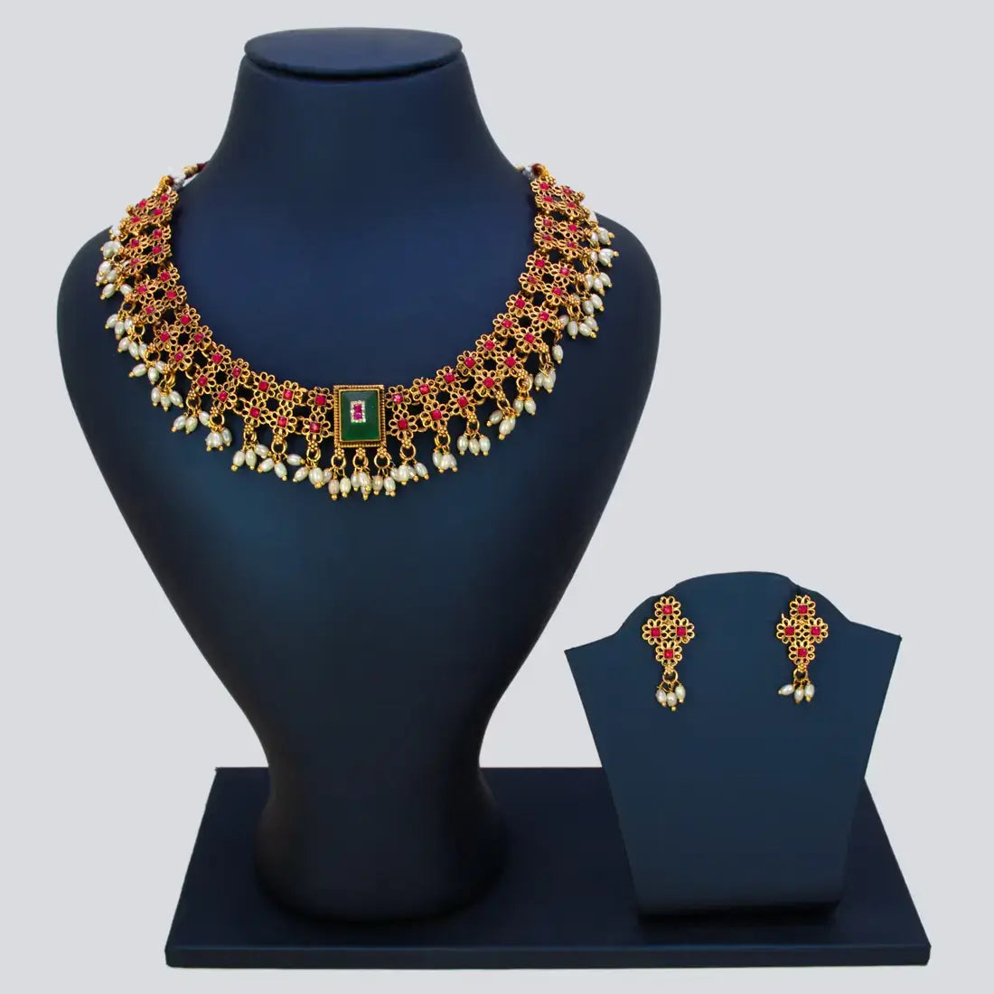 Antique White Pearls Hanging Stone Necklace Set featuring ornate gold detailing and matching earrings on a display bust.