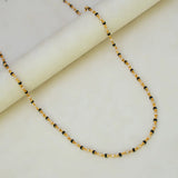Gold Plated Black and White Pearl Chain Necklace for Women displayed on a marble surface, showcasing its elegant design.