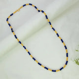 A Blue Crystal and Golden Bead Chain for Women featuring alternating dark blue and gold beads, displayed on a soft white fabric background.