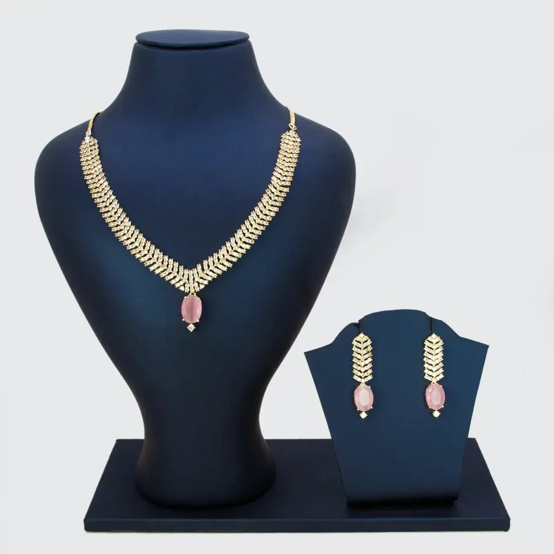 Gold-Plated American Diamond Necklace Set displayed on a jewelry stand with matching earrings and a sophisticated design.