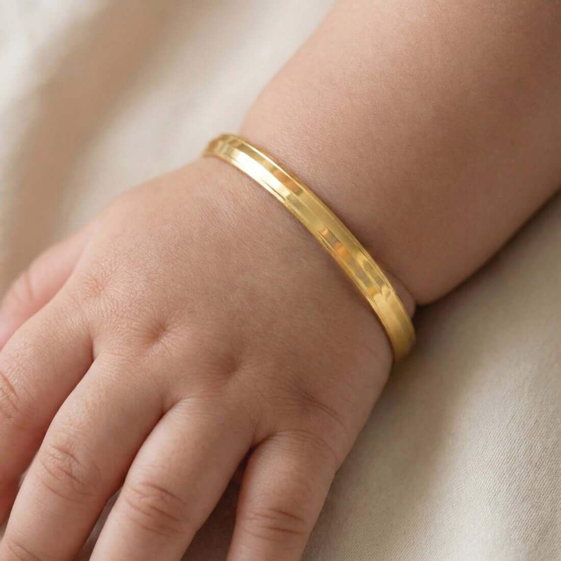 Kada-Style Gold Plated Bangle for Baby Boys worn on a baby's wrist.