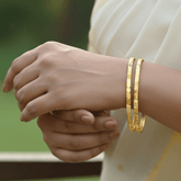 Elegant hand wearing Contemporary Gold Plated Designer Cutting Bangles, showcasing the diamond-cut design.