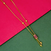 Elegant Gold Plated Cylindrical Stone Pendant Chain with ruby accent on vibrant pink and green background.