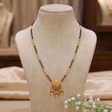 Emerald Ruby CZ Stone Pendant Mangalsutra Necklace displayed on a jewelry stand showcasing its elegance.