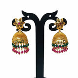 Pair of gold earrings with green and pink beads on a black stand.