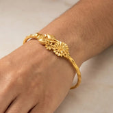 Gold Plated Floral Bouquet Bangle worn on wrist showcasing floral design and radiant yellow gold.