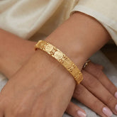 Gold Foamed Lakshmi Kasu Bangle worn on wrist, showcasing intricate goddess-engraved coin designs.