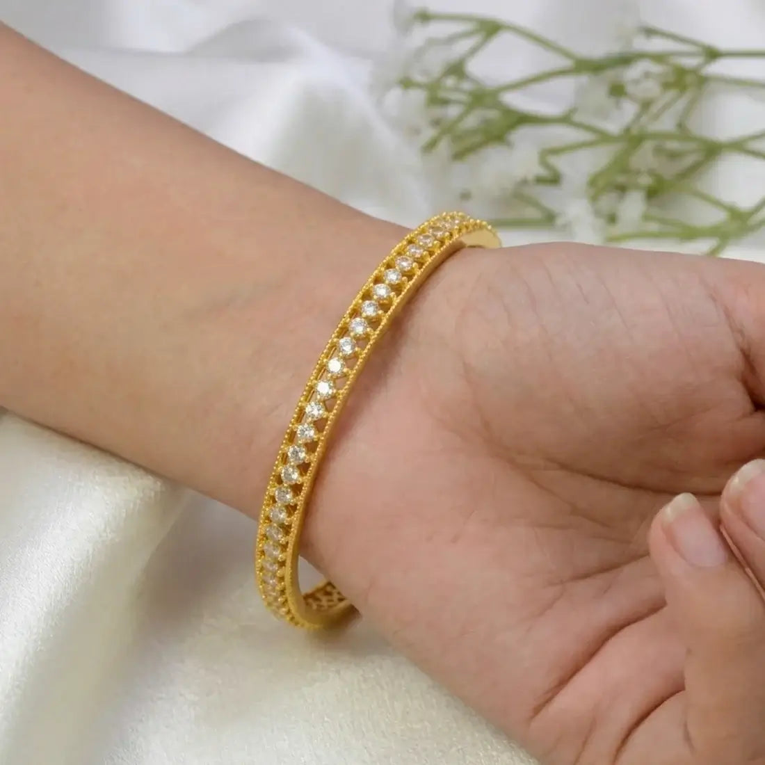 Gold Plated CZ Stone Net Design Bangle on a woman's wrist with sparkling stones and elegant detailing.