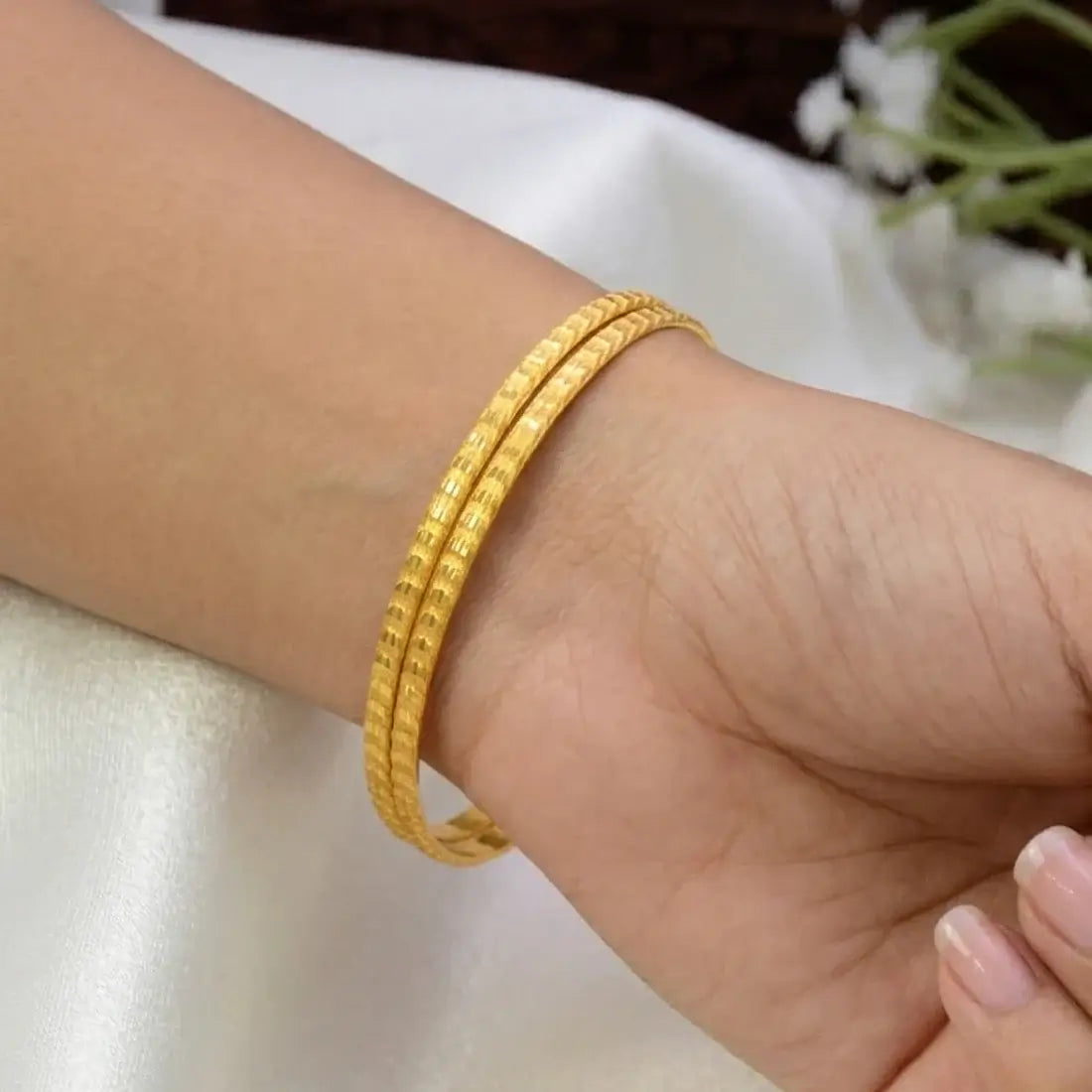 Gold-Plated Matte Designer Bangles worn on a wrist, showcasing their elegant and textured surface.