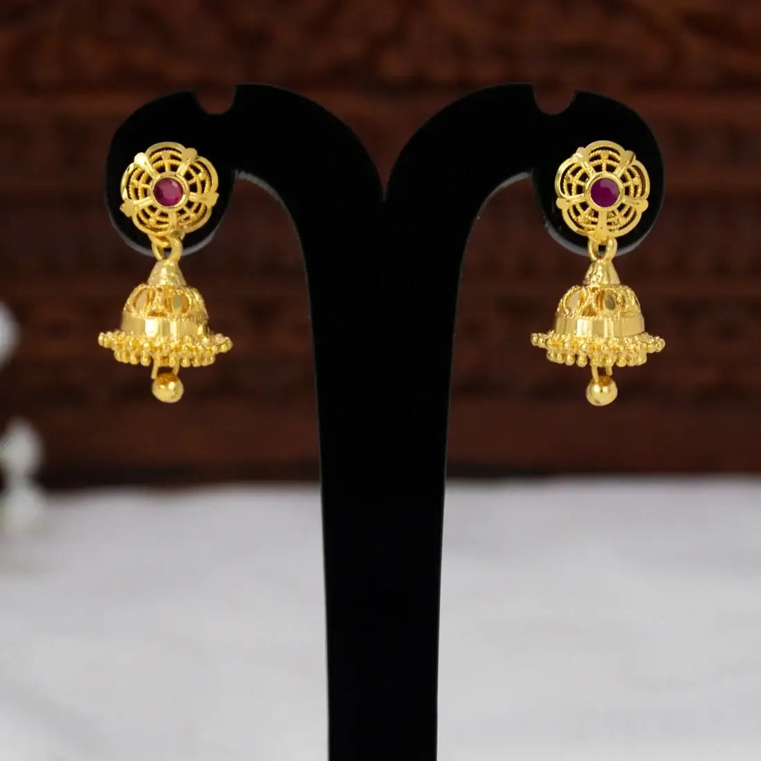 Small Gold Plated Ruby Stone Jhumka Earrings showcasing gold filigree and ruby stone accents.
