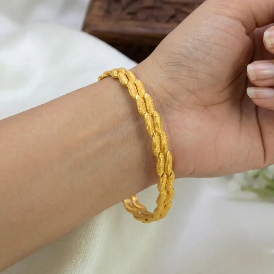 Gold-Plated Designer Bangles – Elegant Textured Gold Bangles worn on a hand, showcasing the intricate textured design.