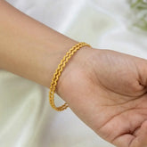 Close-up of a wrist wearing Gold-Plated Matte Thin Wave Bangles, showcasing the delicate wavy pattern and warm matte finish.