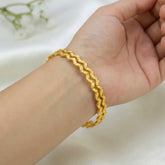 Gold Plated Zig Zag Design Bangles worn on a wrist showcasing the distinctive zigzag design and bright gold finish.