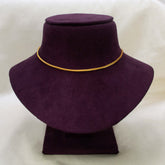 A Gold-Plated Foxtail Chain for babies is displayed on a dark purple velvet jewelry bust against a light beige fabric background.