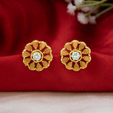 Gold-Plated LCT Stone Floral Stud Earrings showcasing golden petals and a sparkling CZ center on a red fabric background.