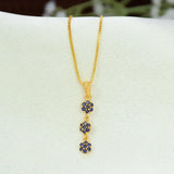 A gold chain necklace with a vertical dangle Gold-Plated Three-tier Stone Floral Drop Pendant featuring three small flower clusters, each set with deep blue stones, displayed on a white jewelry bust.
