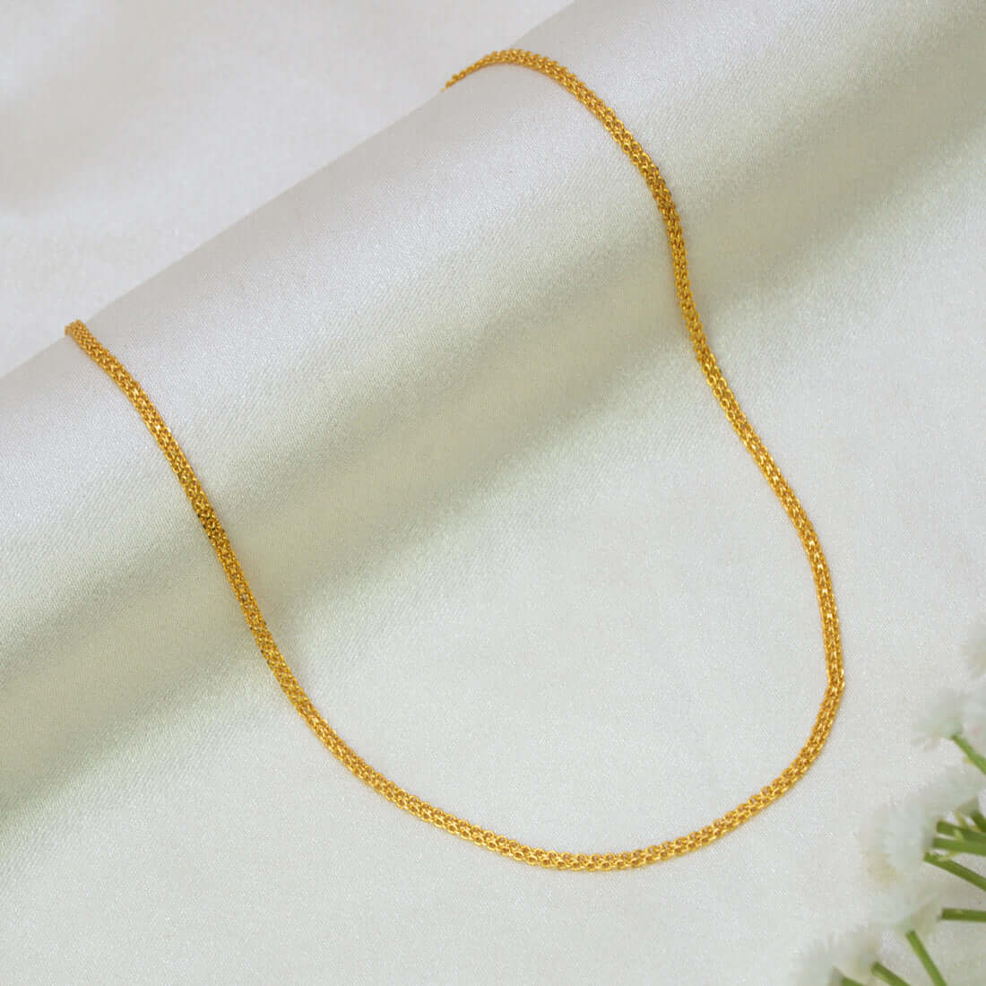 A Gold-Plated Traditional Kids Urvashi Chain- 15" draped in a U-shape over a soft, off-white satin fabric background.