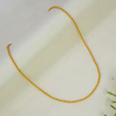 A Gold-Plated Twisted Anjali Baby Chain with a twisted rope texture, laid out in a U-shape on a soft, off-white textured fabric background.