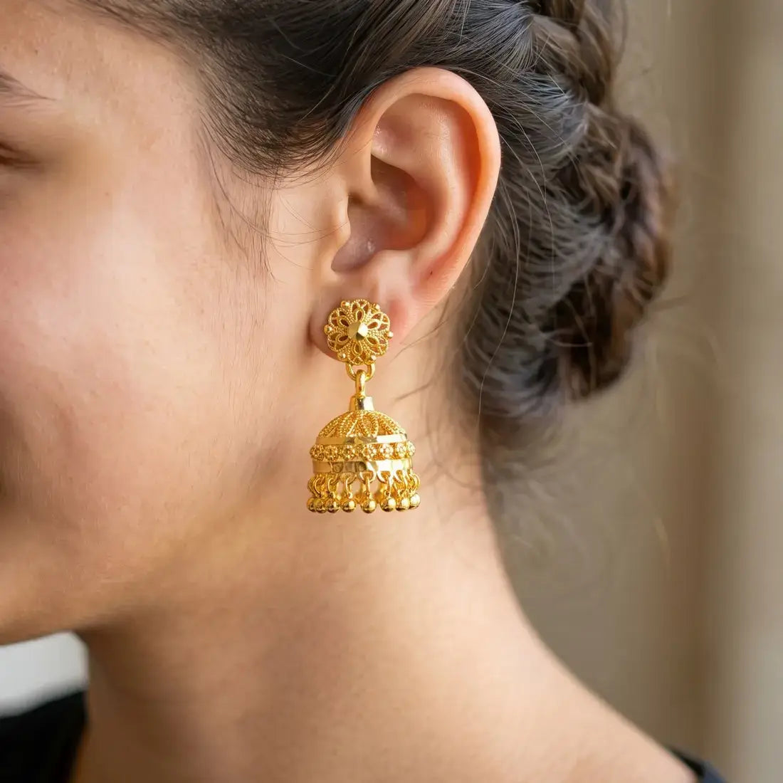 Gold Plated Filigree Designer Jhumka earrings showcased on a model's ear with intricate detailing and design.
