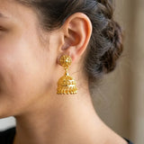 Gold Plated Filigree Designer Jhumka earrings showcased on a model's ear with intricate detailing and design.