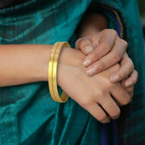 Elegant Matte Gold Plated Designer Bangles worn elegantly on a hand, showcasing delicate patterns and a matte finish.
