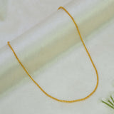 A Gold Plated Cutting Design Baby Chain necklace draped in a U-shape over a soft, off-white textured fabric background.
