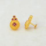 Gold Plated Floral Stone Studded Stud Earrings showcasing a textured gold finish with ruby stones.