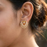 Dazzling Gold Plated Stone Heart Stud Earrings worn by a model, showcasing sparkling stones and heart design.