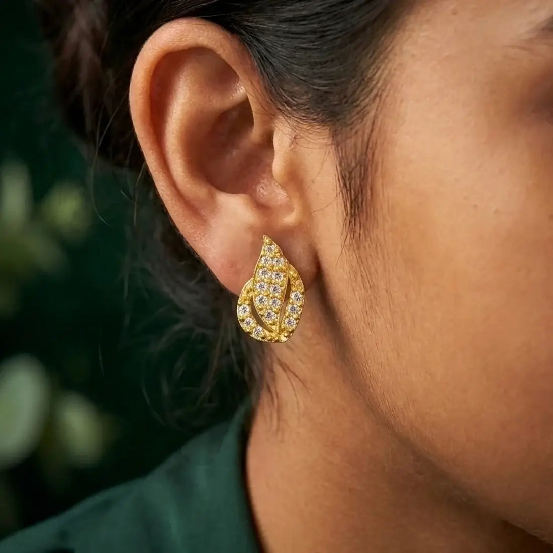 Gold Plated Leaf Model Stone Stud Earrings highlighting a gold finish and vibrant Ruby/CZ stones worn by a model.