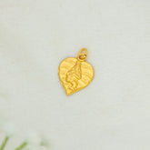 A Gold Plated Traditional Baby Krishna Alila Pendant with an embossed figure, displayed on a textured off-white surface.