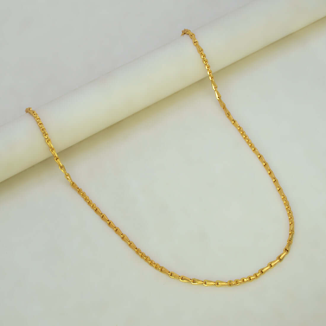 Stylish Gold Plated Cutting Bhanu Priya Chain displayed on a smooth surface, showcasing its elegant design and shine.