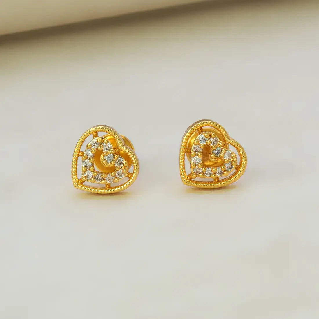 Gold Heart Design Stone Stud Earrings featuring intricate heart shapes with sparkling stones in a premium gold finish.