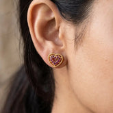 Gold Heart Design Stone Stud Earrings featuring ruby stones worn on an ear, showcasing elegance and romance.
