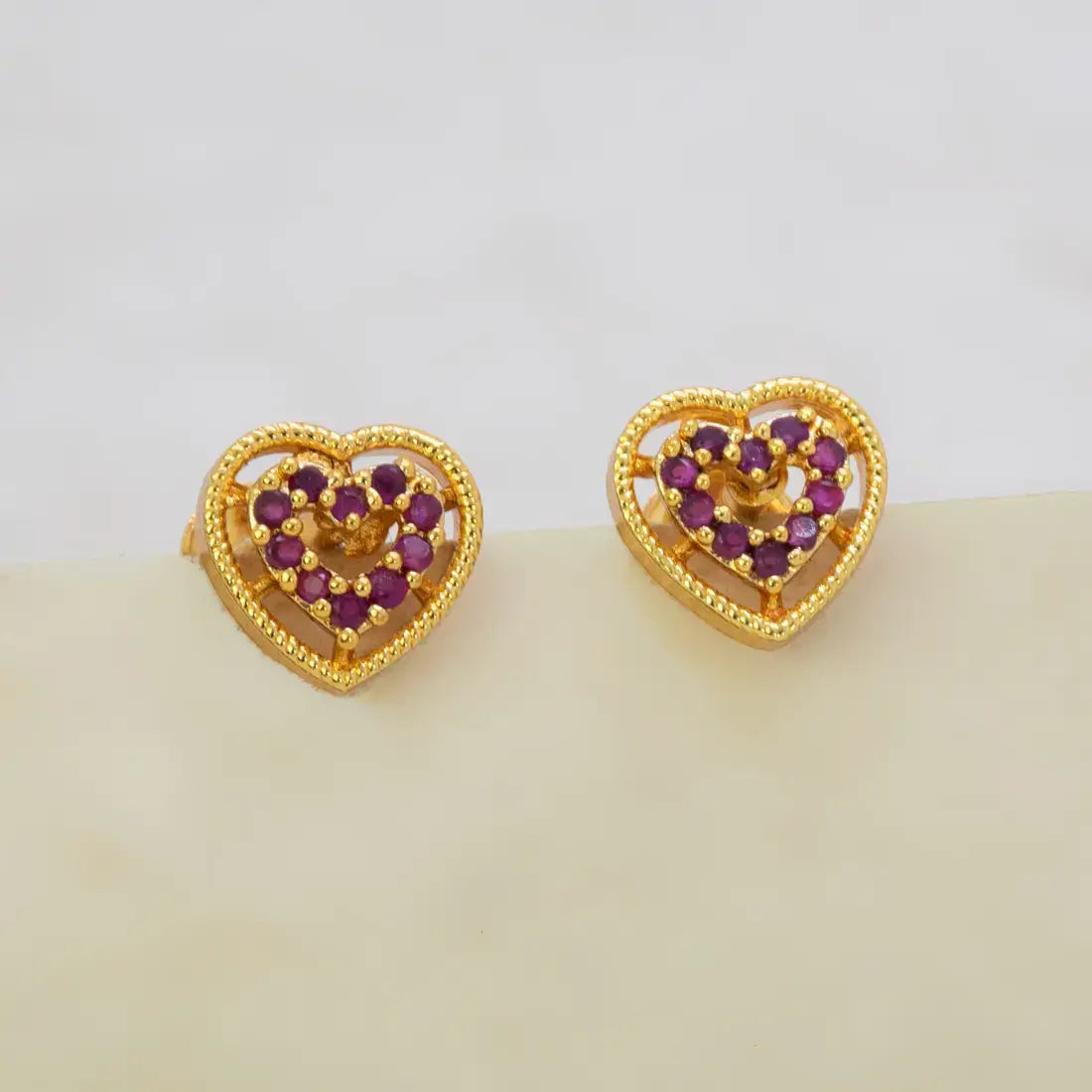 Gold Heart Design Stone Stud Earrings featuring ruby stones in intricate heart shapes with a premium gold finish.