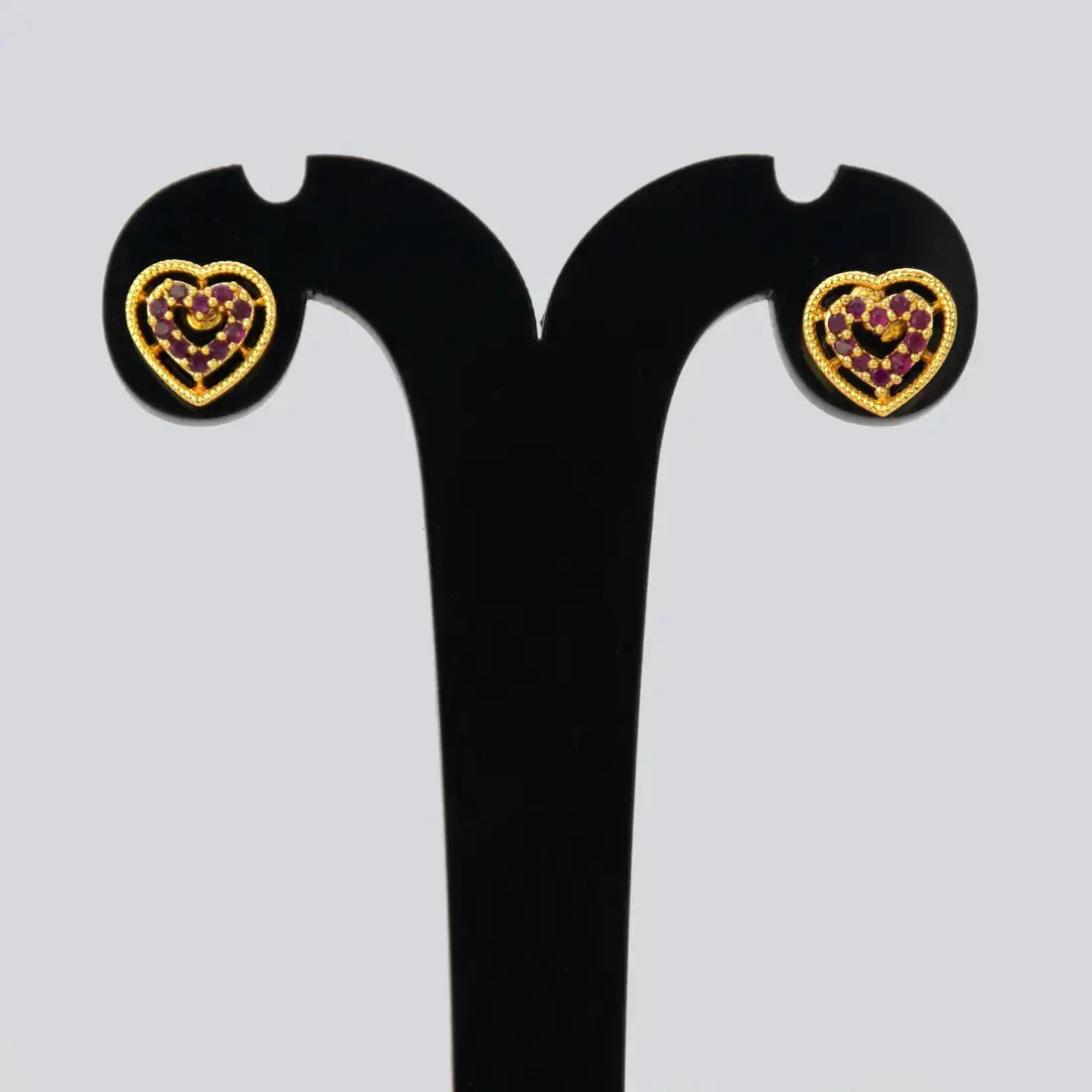 Gold Heart Design Stone Stud Earrings featuring intricate heart shapes with sparkling rubies and a premium gold finish.