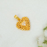 A Heart-Shaped Gold-Plated CZ Pendant For Women with a textured beaded border and a small central heart set with a clear stone, displayed on a textured white fabric background.