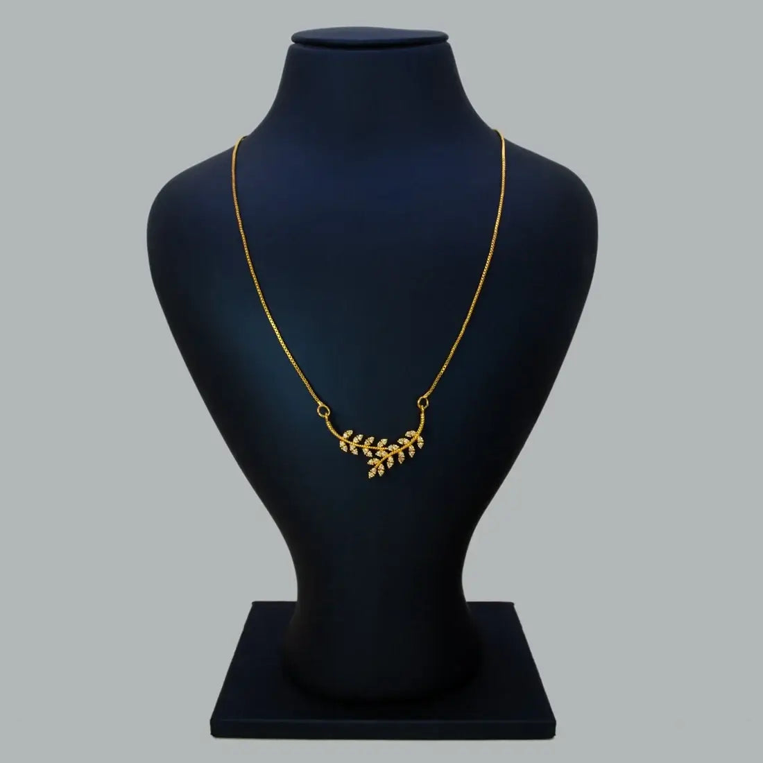 Gold Plated American Diamond Leaf Pendant Necklace displayed on a black bust mannequin.