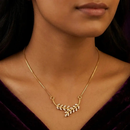 Gold Plated American Diamond Leaf Pendant Necklace worn by a model, featuring a sparkling leaf branch design.