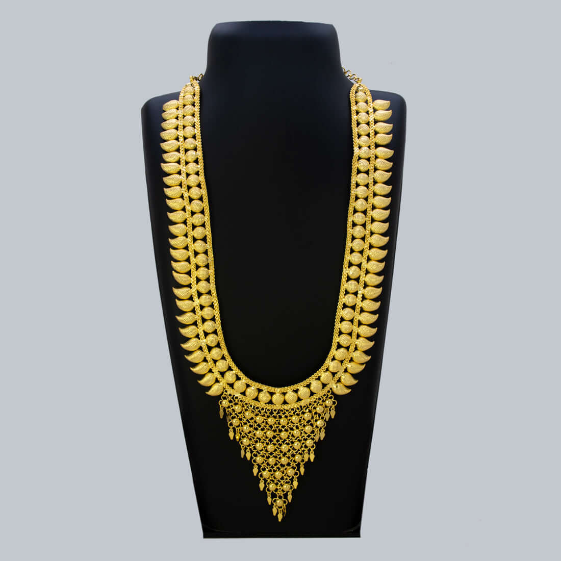 Elegant Gold Plated Bridal Mango Long Necklace displayed on a black stand, showcasing intricate gold plating and mango motifs.