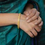 Stylish Matte Gold Plated Textured Designer Bangles worn on a hand with elegant grip, complementing a traditional outfit.