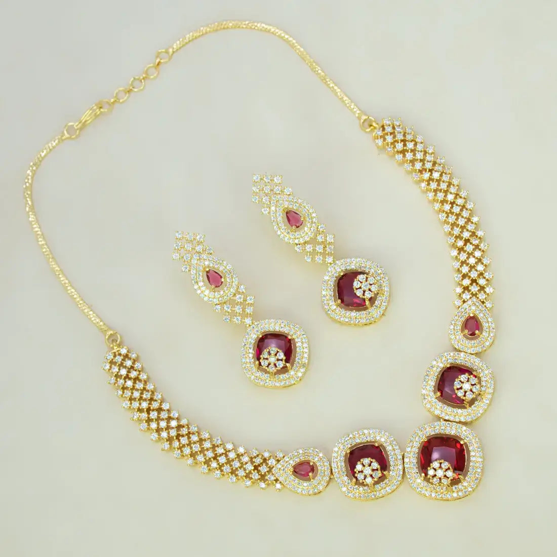 CZ Stone Necklace Set featuring gold-plated design with Ruby Red stones and matching earrings for party wear.